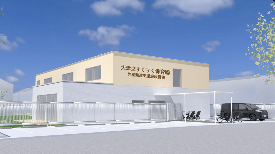 スクリーンショット 2026-09-18 112038 | 保育士求人|大阪・兵庫・関西の保育士・幼稚園教諭の就職転職支援|保育のせかい Exterior view of a beige daycare center with Japanese signage, fenced parking area, bikes, and a black van under a canopy against a blue sky.