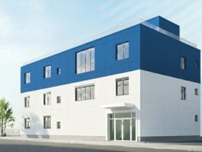 Modern three-story building with a white lower half and blue upper façade, glass entry doors at the front.