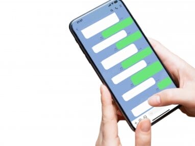 Person holding a smartphone showing a chat screen with alternating white and green message bubbles on a blue background